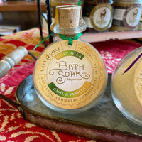 A 9oz glass jar of Basil & Vanilla Bath soak with goat milk and magnesium.
