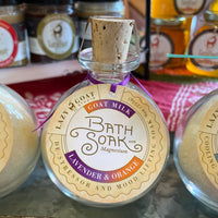 A 9oz glass jar of Lavender & Orange Bath soak with goat milk and magnesium.