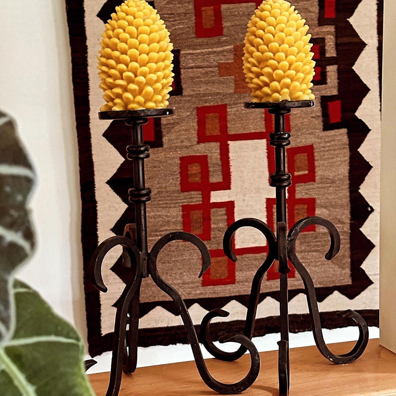 Two large Beeswax Pine Cones on metal stands.